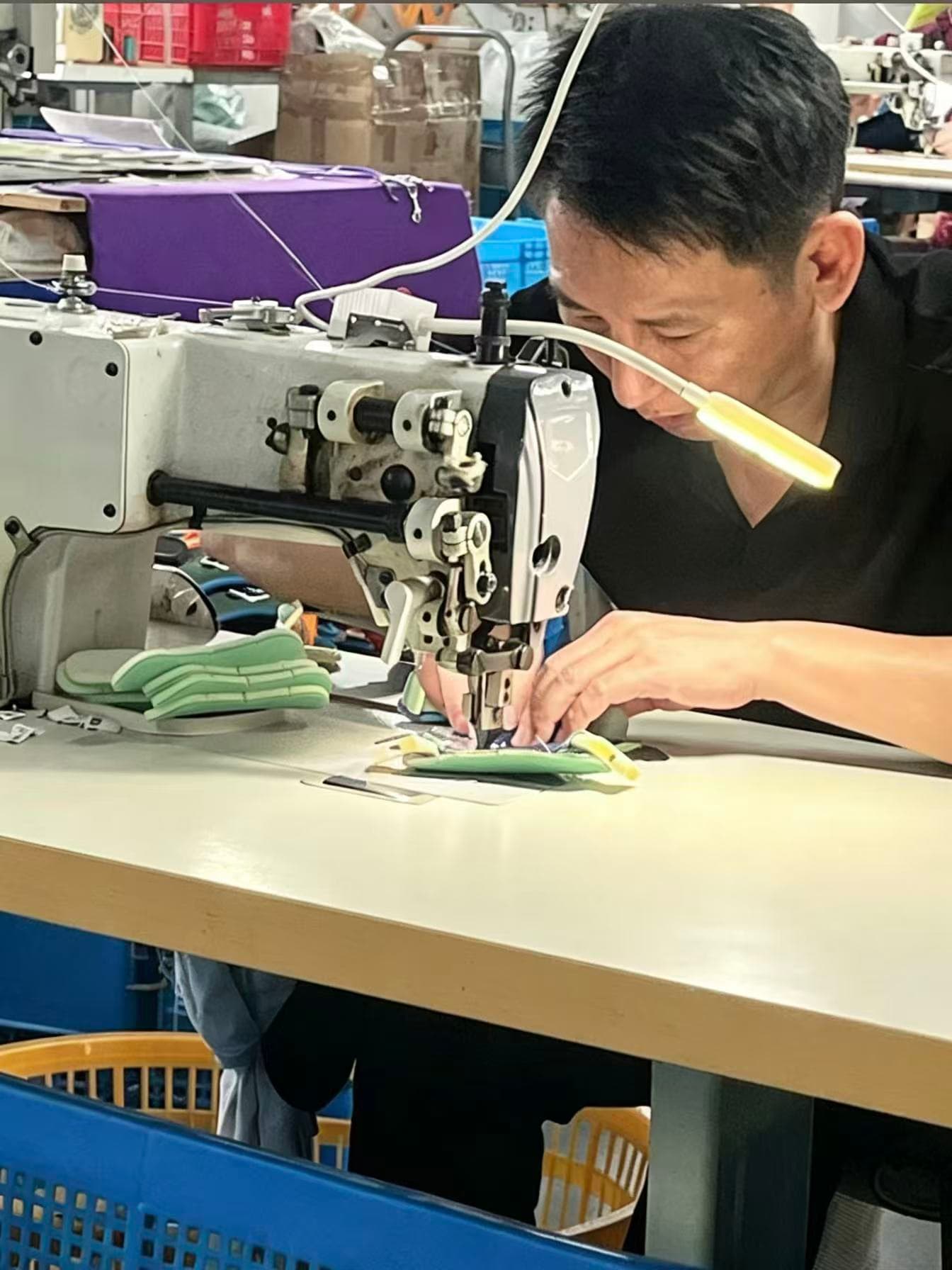 Worker sewing pet outdoor product details at a manufacturing partner workshop