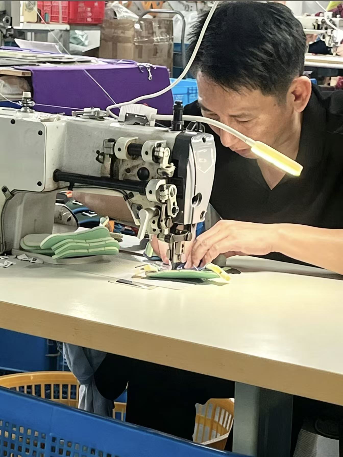Worker sewing pet outdoor product details at a manufacturing partner workshop
